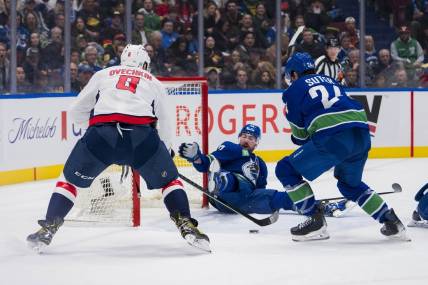 Mar 16, 2024; Vancouver, British Columbia, CAN; Vancouver Canucks defenseman Filip Hronek (17) and forward Pius Suter (24) watch as Washington Capitals forward Alex Ovechkin (8) scores on the Vancouver goal in the second period at Rogers Arena. Mandatory Credit: Bob Frid-USA TODAY Sports