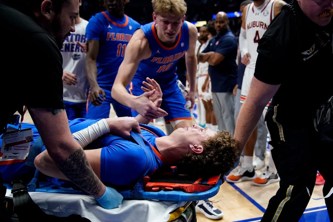 Florida center Micah Handlogten (3) is tended to after an injury during the first half of the SEC tournament championship game against Auburn at Bridgestone Arena in Nashville, Tenn., Sunday, March 17, 2024.