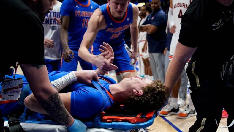 Florida center Micah Handlogten (3) is tended to after an injury during the first half of the SEC tournament championship game against Auburn at Bridgestone Arena in Nashville, Tenn., Sunday, March 17, 2024.