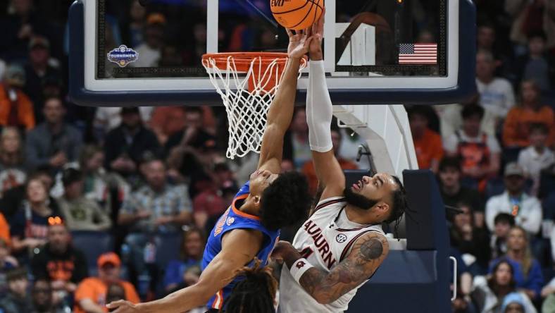 Mar 17, 2024; Nashville, TN, USA; Auburn Tigers forward Johni Broome (4) blocks Florida Gators guard Zyon Pullin (0) in the first half in the SEC Tournament championship game at Bridgestone Arena. Mandatory Credit: Christopher Hanewinckel-USA TODAY Sports