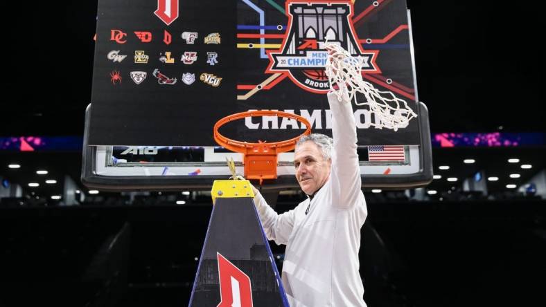 Mar 17, 2024; Brooklyn, NY, USA;  Duquesne Dukes head coach Keith Dambrot cuts the nets after winning the Atlantic 10 Tournament Championship at Barclays Center. Mandatory Credit: Wendell Cruz-USA TODAY Sports