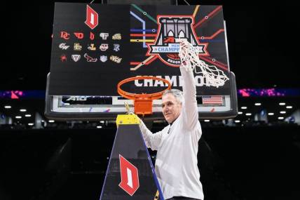 Mar 17, 2024; Brooklyn, NY, USA;  Duquesne Dukes head coach Keith Dambrot cuts the nets after winning the Atlantic 10 Tournament Championship at Barclays Center. Mandatory Credit: Wendell Cruz-USA TODAY Sports
