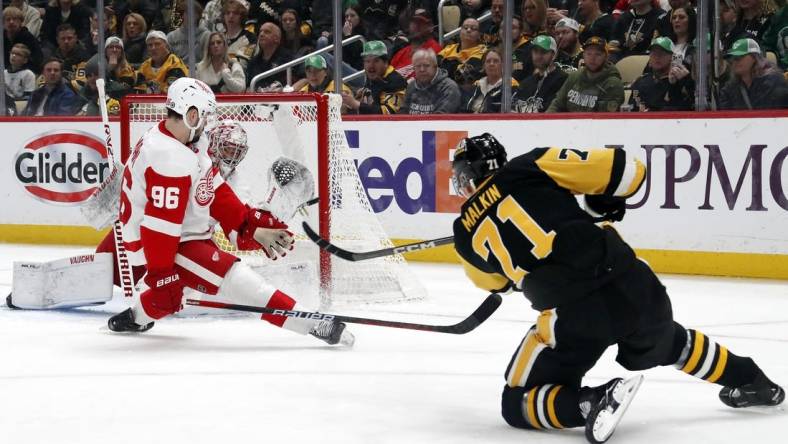 Mar 17, 2024; Pittsburgh, Pennsylvania, USA;  Detroit Red Wings goaltender Alex Lyon (rear) makes a glove save against Pittsburgh Penguins center Evgeni Malkin (71) as Detroit defenseman Jake Walman (96) defends during the first period at PPG Paints Arena. Mandatory Credit: Charles LeClaire-USA TODAY Sports