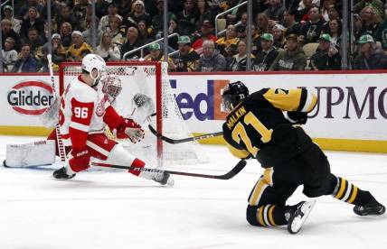 Mar 17, 2024; Pittsburgh, Pennsylvania, USA;  Detroit Red Wings goaltender Alex Lyon (rear) makes a glove save against Pittsburgh Penguins center Evgeni Malkin (71) as Detroit defenseman Jake Walman (96) defends during the first period at PPG Paints Arena. Mandatory Credit: Charles LeClaire-USA TODAY Sports