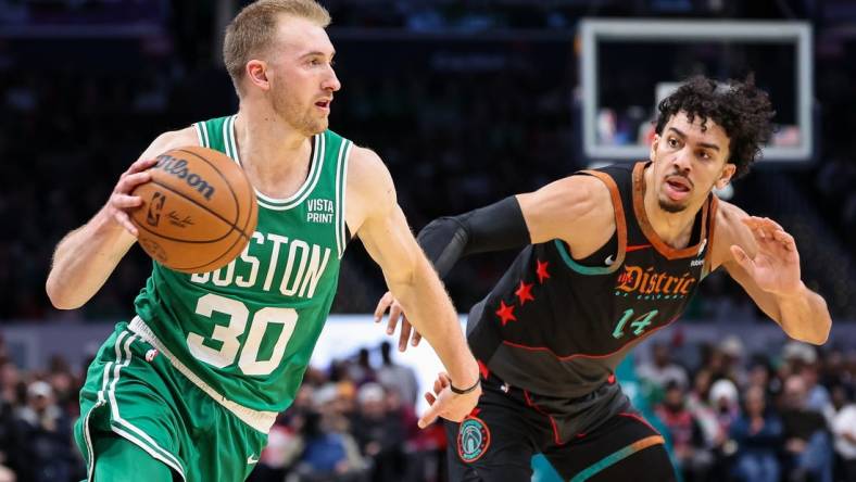 Mar 17, 2024; Washington, District of Columbia, USA; Boston Celtics forward Sam Hauser (30) drives to the basket against Washington Wizards guard Jules Bernard (14) during the first half of the game at Capital One Arena. Mandatory Credit: Scott Taetsch-USA TODAY Sports