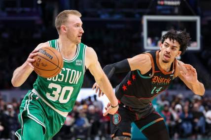 Mar 17, 2024; Washington, District of Columbia, USA; Boston Celtics forward Sam Hauser (30) drives to the basket against Washington Wizards guard Jules Bernard (14) during the first half of the game at Capital One Arena. Mandatory Credit: Scott Taetsch-USA TODAY Sports