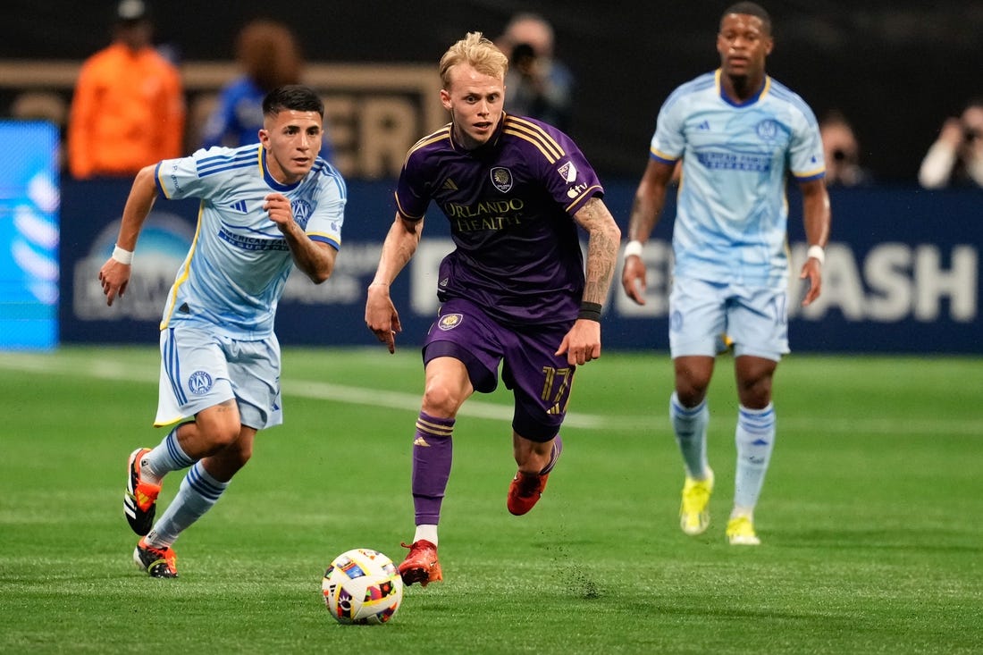 Mar 17, 2024; Atlanta, Georgia, USA; Orlando City midfielder Dagur Thorhallsson (17) dribbles the ball as Atlanta United midfielder Thiago Almada (10) pursues during the first half at Mercedes-Benz Stadium. Mandatory Credit: Dale Zanine-USA TODAY Sports