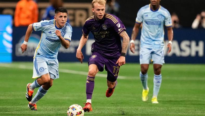 Mar 17, 2024; Atlanta, Georgia, USA; Orlando City midfielder Dagur Thorhallsson (17) dribbles the ball as Atlanta United midfielder Thiago Almada (10) pursues during the first half at Mercedes-Benz Stadium. Mandatory Credit: Dale Zanine-USA TODAY Sports