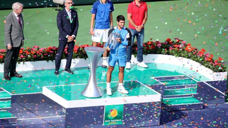 Carlos Alcaraz holds the trophy after defeating Daniil Medvedev 7-6(5), 6-1in the BNP Paribas Open championship match at the Indian Wells Tennis Garden in Indian Wells, Calif., on Sunday, March 17, 2024.