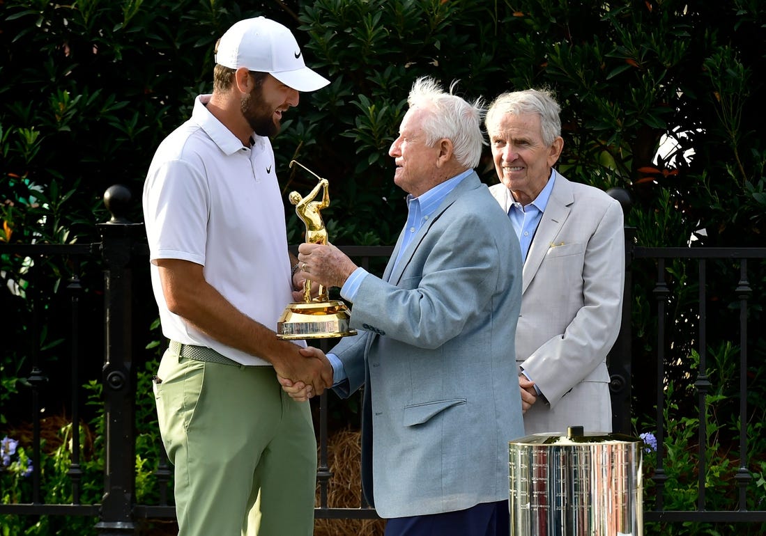 Deane Beman, the PGA Tour Commissioner to oversee the first Players Championship presents Scottie Scheffler his Gold Man tournament trophy as former Commissioner Tim Finchem looks on during the trophy ceremony following the fourth and final round of The Players Championship PGA golf tournament Sunday, March 17, 2024 at TPC Sawgrass in Ponte Vedra Beach, Fla. [Bob Self/Florida Times-Union]