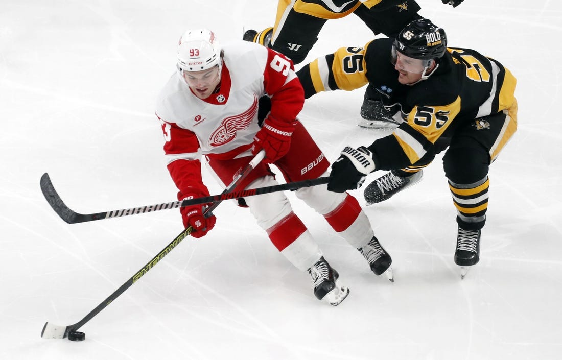 Mar 17, 2024; Pittsburgh, Pennsylvania, USA;  Detroit Red Wings right wing Alex DeBrincat (93) skates with he puck against Pittsburgh Penguins center Noel Acciari (55) during the third period at PPG Paints Arena. Pittsburgh won 6-3. Mandatory Credit: Charles LeClaire-USA TODAY Sports