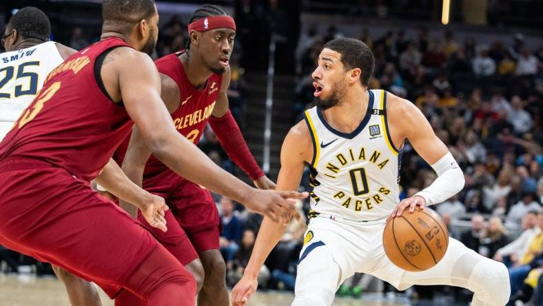 Mar 18, 2024; Indianapolis, Indiana, USA; Indiana Pacers guard Tyrese Haliburton (0) dribbles the ball while Cleveland Cavaliers guard Caris LeVert (3) defends in the first half at Gainbridge Fieldhouse. Mandatory Credit: Trevor Ruszkowski-USA TODAY Sports