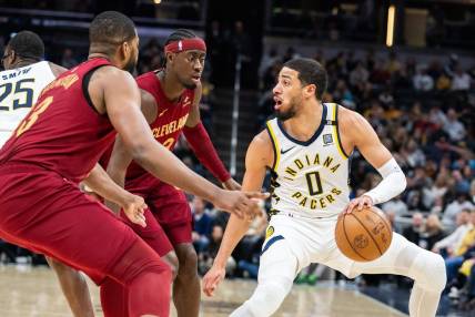 Mar 18, 2024; Indianapolis, Indiana, USA; Indiana Pacers guard Tyrese Haliburton (0) dribbles the ball while Cleveland Cavaliers guard Caris LeVert (3) defends in the first half at Gainbridge Fieldhouse. Mandatory Credit: Trevor Ruszkowski-USA TODAY Sports