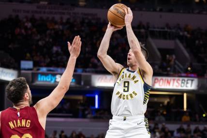 Mar 18, 2024; Indianapolis, Indiana, USA; Indiana Pacers guard T.J. McConnell (9) shoots the ball while Cleveland Cavaliers forward Georges Niang (20) defends in the first half at Gainbridge Fieldhouse. Mandatory Credit: Trevor Ruszkowski-USA TODAY Sports