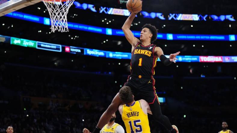 Mar 18, 2024; Los Angeles, California, USA; Atlanta Hawks forward Jalen Johnson (1) dunks the ball over Los Angeles Lakers guard Austin Reaves (15) in the first half at Crypto.com Arena. Mandatory Credit: Kirby Lee-USA TODAY Sports