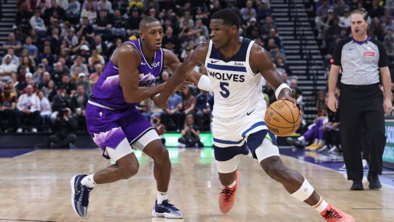 Mar 18, 2024; Salt Lake City, Utah, USA; Minnesota Timberwolves guard Anthony Edwards (5) drives against Utah Jazz guard Kris Dunn (11) during the third quarter at Delta Center. Mandatory Credit: Rob Gray-USA TODAY Sports