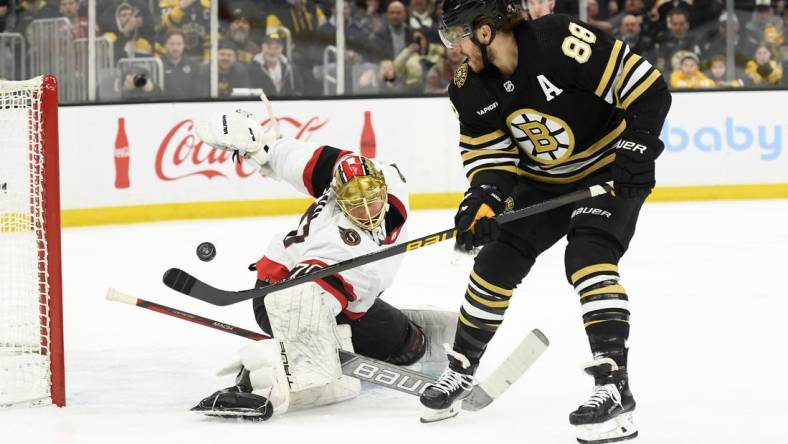 Mar 19, 2024; Boston, Massachusetts, USA;  Boston Bruins right wing David Pastrnak (88) scores a goal past Ottawa Senators goaltender Joonas Korpisalo (70) during the first period at TD Garden. Mandatory Credit: Bob DeChiara-USA TODAY Sports