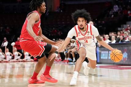 Mar 19, 2024; Columbus, OH, USA; Ohio State Buckeyes guard Taison Chatman (3) dribbles around Cornell Big Red forward Guy Ragland Jr. (21) during the first half of the NIT basketball game at Value City Arena.