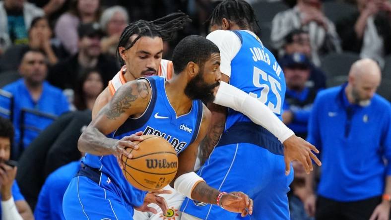 Mar 19, 2024; San Antonio, Texas, USA;  Dallas Mavericks guard Kyrie Irving (11) dribbles past San Antonio Spurs guard Tre Jones (33) in the first half at Frost Bank Center. Mandatory Credit: Daniel Dunn-USA TODAY Sports