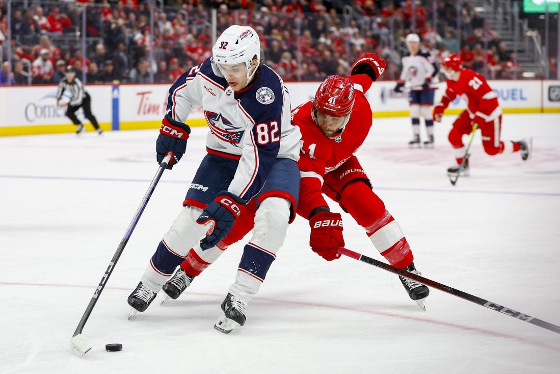 Mar 19, 2024; Detroit, Michigan, USA; Columbus Blue Jackets left wing Mikael Pyyhtia (82) handles the puck against Detroit Red Wings defenseman Shayne Gostisbehere (41) during the first period of the game against the Detroit Red Wings at Little Caesars Arena. Mandatory Credit: Brian Bradshaw Sevald-USA TODAY Sports