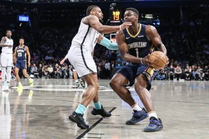 Mar 19, 2024; Brooklyn, New York, USA;  New Orleans Pelicans forward Zion Williamson (1) looks to drive past Brooklyn Nets guard Dennis Smith Jr. (4) in the second quarter at Barclays Center. Mandatory Credit: Wendell Cruz-USA TODAY Sports