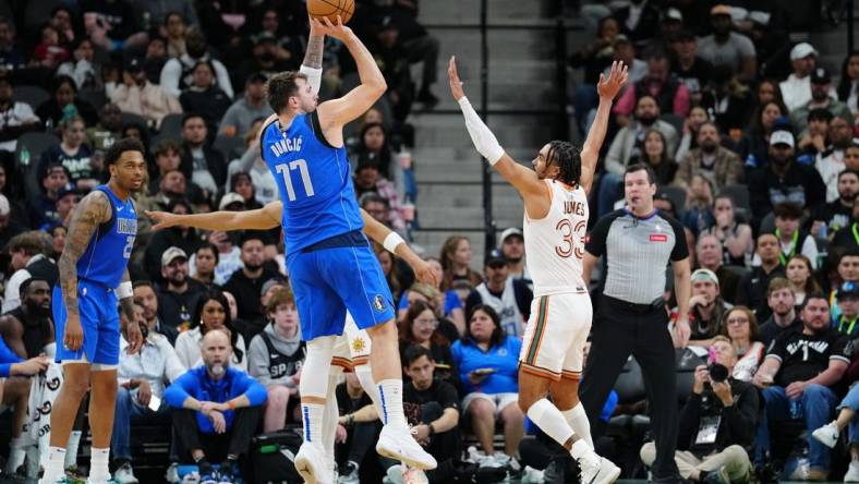 Mar 19, 2024; San Antonio, Texas, USA;  Dallas Mavericks guard Luka Doncic (77) shoots over San Antonio Spurs guard Tre Jones (33) in the first half at Frost Bank Center. Mandatory Credit: Daniel Dunn-USA TODAY Sports