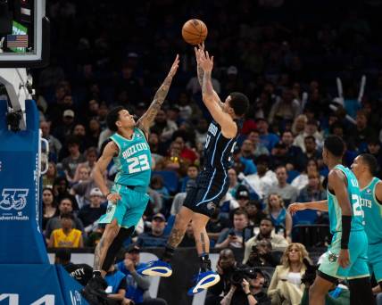 Mar 19, 2024; Orlando, Florida, USA; Orlando Magic guard Cole Anthony (50) shoots the ball over Charlotte Hornets guard Tre Mann (23) in the fourth quarter at KIA Center. Mandatory Credit: Jeremy Reper-USA TODAY Sports