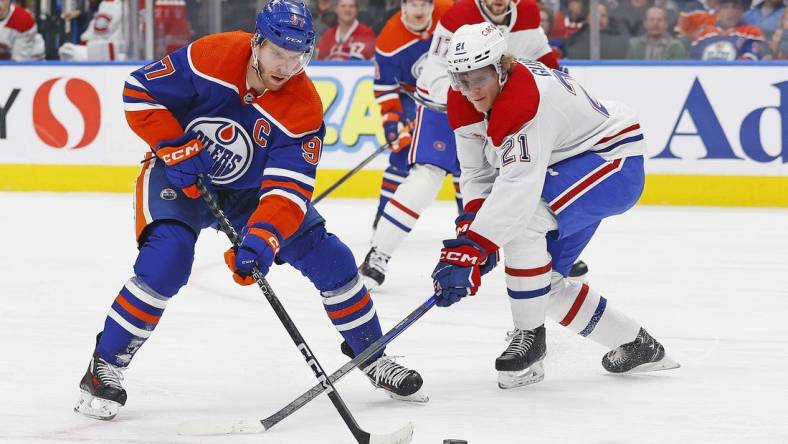 Mar 16, 2024; Edmonton, Alberta, CAN; Edmonton Oilers forward Connor McDavid (97) tries to carry the puck around Montreal Canadiens defensemen Kaiden Guhle (21) during the first period at Rogers Place. Mandatory Credit: Perry Nelson-USA TODAY Sports