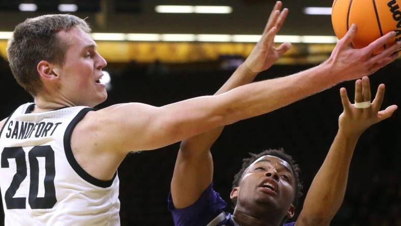 Iowa   s Payton Sandfort (20) and Kansas State   s Tylor Perry (2) reach for a loose ball in a first-round NIT game Tuesday, March 19, 2024 at Carver-Hawkeye Arena in Iowa City, Iowa.