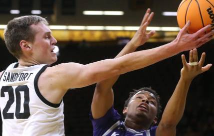 Iowa   s Payton Sandfort (20) and Kansas State   s Tylor Perry (2) reach for a loose ball in a first-round NIT game Tuesday, March 19, 2024 at Carver-Hawkeye Arena in Iowa City, Iowa.