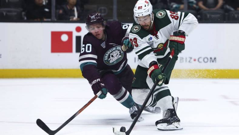 Mar 19, 2024; Anaheim, California, USA; Minnesota Wild center Frederick Gaudreau (89) skates with the puck against Anaheim Ducks defenseman Jackson LaCombe (60) during the third period of a game at Honda Center. Mandatory Credit: Jessica Alcheh-USA TODAY Sports