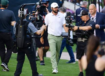 Scottie Scheffler is surrounded by cameras as he makes his way to the trophy riser after winning the tournament for the second year in a row at The Players Championship PGA golf tournament Sunday, March 17, 2024 at TPC Sawgrass in Ponte Vedra Beach, Fla.