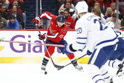 Mar 20, 2024; Washington, District of Columbia, USA; Washington Capitals left wing Sonny Milano (15) controls the puck in front of Toronto Maple Leafs defenseman Joel Edmundson (20) during the first period at Capital One Arena. Mandatory Credit: Amber Searls-USA TODAY Sports