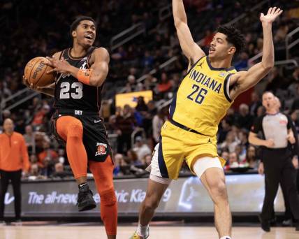 Mar 20, 2024; Detroit, Michigan, USA; Detroit Pistons guard Jaden Ivey (23) drives to the basket next to Indiana Pacers guard Ben Sheppard (26) in the first half at Little Caesars Arena. Mandatory Credit: David Reginek-USA TODAY Sports