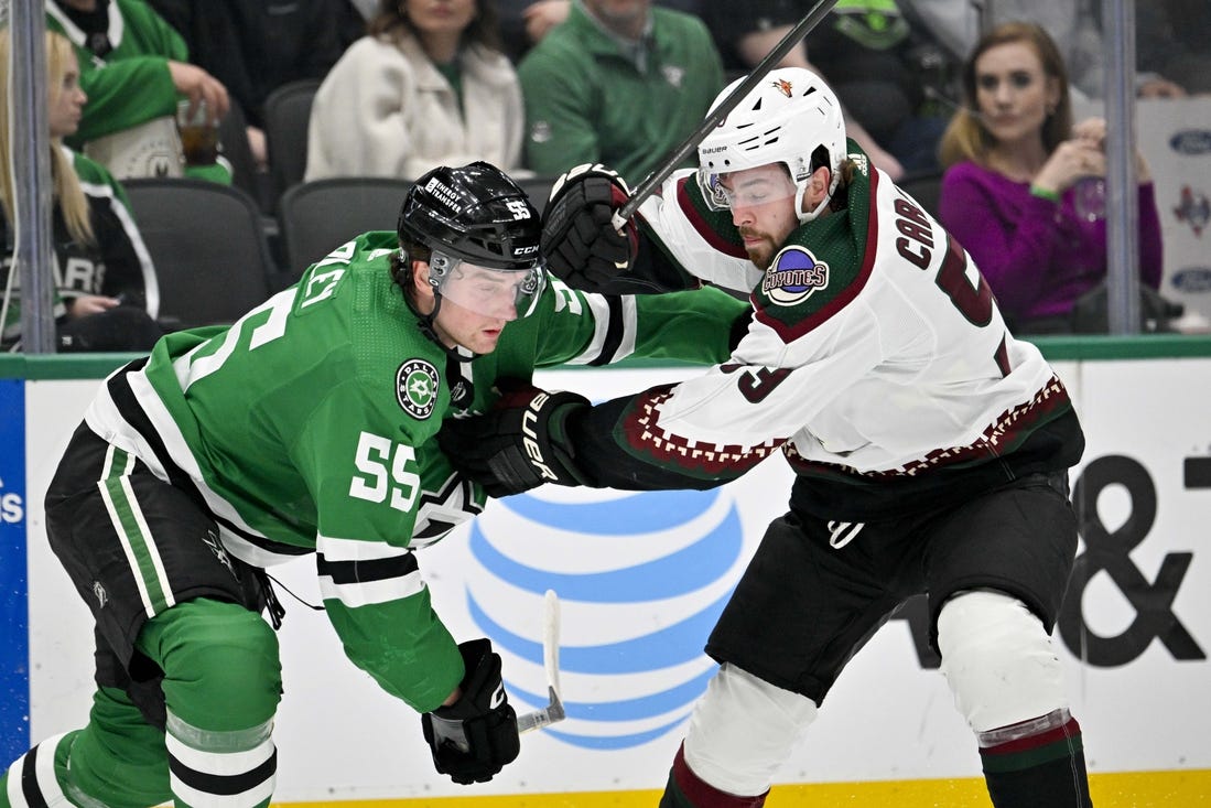 Mar 20, 2024; Dallas, Texas, USA; Arizona Coyotes left wing Michael Carcone (53) tries to skate past Dallas Stars defenseman Thomas Harley (55) during the first period at the American Airlines Center. Mandatory Credit: Jerome Miron-USA TODAY Sports