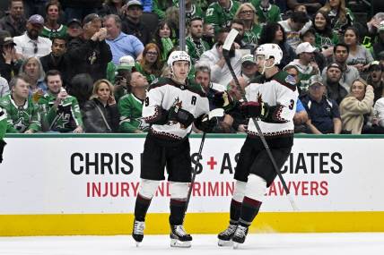 Mar 20, 2024; Dallas, Texas, USA; Arizona Coyotes right wing Clayton Keller (9) and defenseman Josh Brown (3) celebrates a goal scored by Keller against the Dallas Stars during the first period at the American Airlines Center. Mandatory Credit: Jerome Miron-USA TODAY Sports