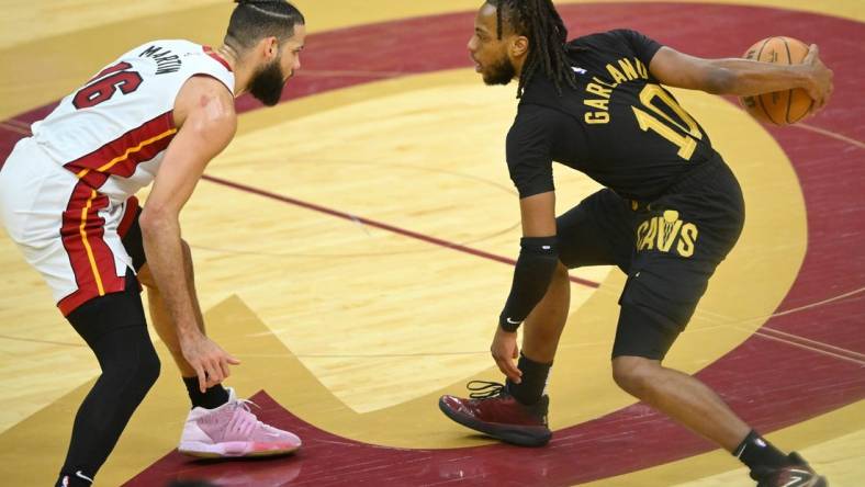 Mar 20, 2024; Cleveland, Ohio, USA; Cleveland Cavaliers guard Darius Garland (10) dribbles beside Miami Heat forward Caleb Martin (16) in the fourth quarter at Rocket Mortgage FieldHouse. Mandatory Credit: David Richard-USA TODAY Sports