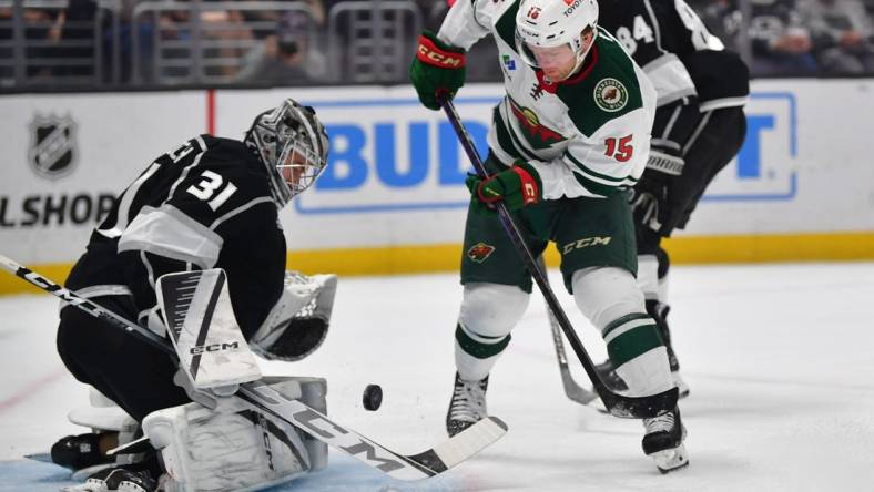 Mar 20, 2024; Los Angeles, California, USA; Los Angeles Kings goaltender David Rittich (31) blocks a shot against Minnesota Wild center Mason Shaw (15) during the first period at Crypto.com Arena. Mandatory Credit: Gary A. Vasquez-USA TODAY Sports