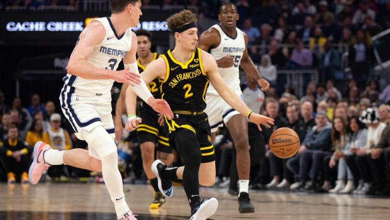 Mar 20, 2024; San Francisco, California, USA; Golden State Warriors guard Brandin Podziemski (2) drives between Memphis Grizzlies forward Jake LaRavia (3) and center Trey Jemison (55) during the first quarter at Chase Center. Mandatory Credit: D. Ross Cameron-USA TODAY Sports