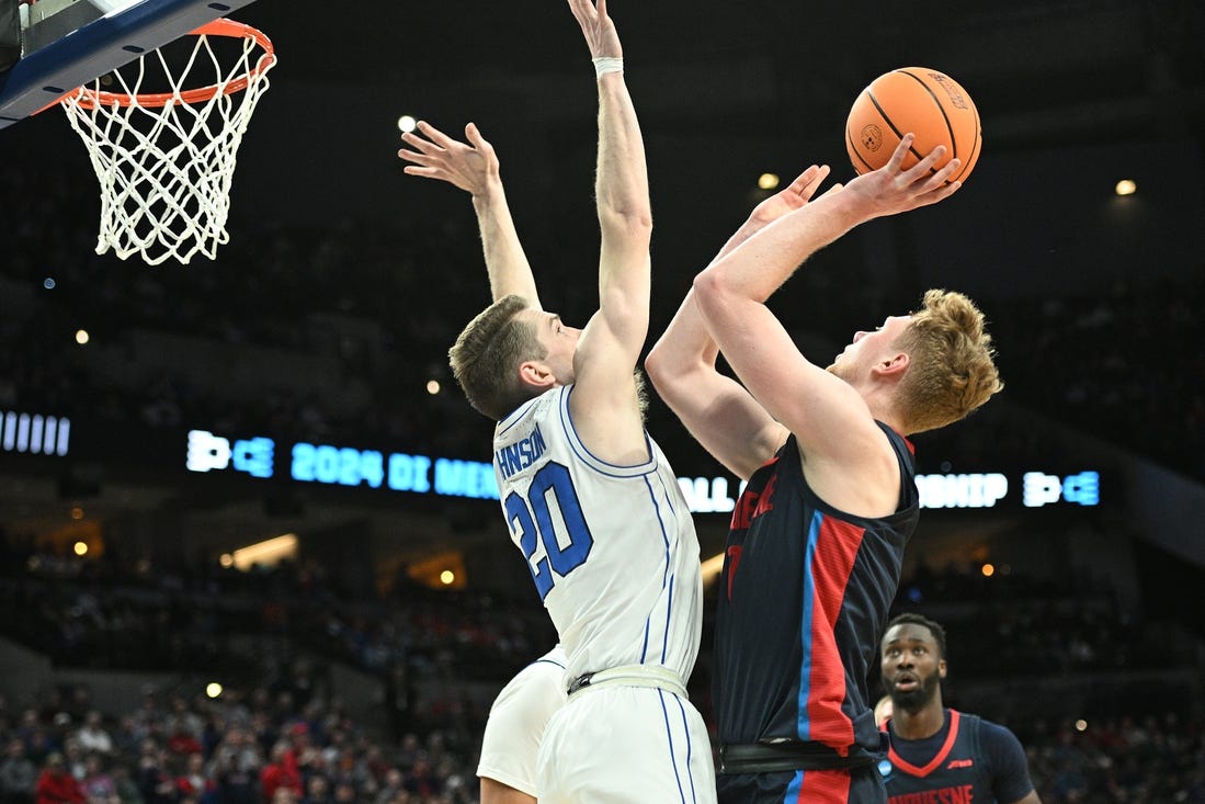 Mar 21, 2024; Omaha, NE, USA; Duquesne Dukes forward Jakub Necas (7) shoots against Brigham Young Cougars guard Spencer Johnson (20) in the first half during the first round of the NCAA Tournament at CHI Health Center Omaha. Mandatory Credit: Steven Branscombe-USA TODAY Sports