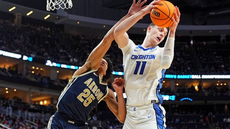 Mar 21, 2024; Pittsburgh, PA, USA; Creighton Bluejays center Ryan Kalkbrenner (11) grabs a rebound against Akron Zips forward Enrique Freeman (25) during the second half in the first round of the 2024 NCAA Tournament at PPG Paints Arena. Mandatory Credit: Gregory Fisher-USA TODAY Sports