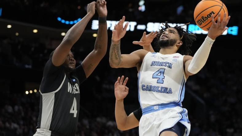 March 21, 2024, Charlotte, NC, USA; North Carolina Tar Heels guard RJ Davis (4) shoots against Wagner Seahawks forward Tyje Kelton (4) in the first round of the 2024 NCAA Tournament at the Spectrum Center. Mandatory Credit: Bob Donnan-USA TODAY Sports