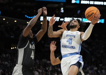March 21, 2024, Charlotte, NC, USA; North Carolina Tar Heels guard RJ Davis (4) shoots against Wagner Seahawks forward Tyje Kelton (4) in the first round of the 2024 NCAA Tournament at the Spectrum Center. Mandatory Credit: Bob Donnan-USA TODAY Sports