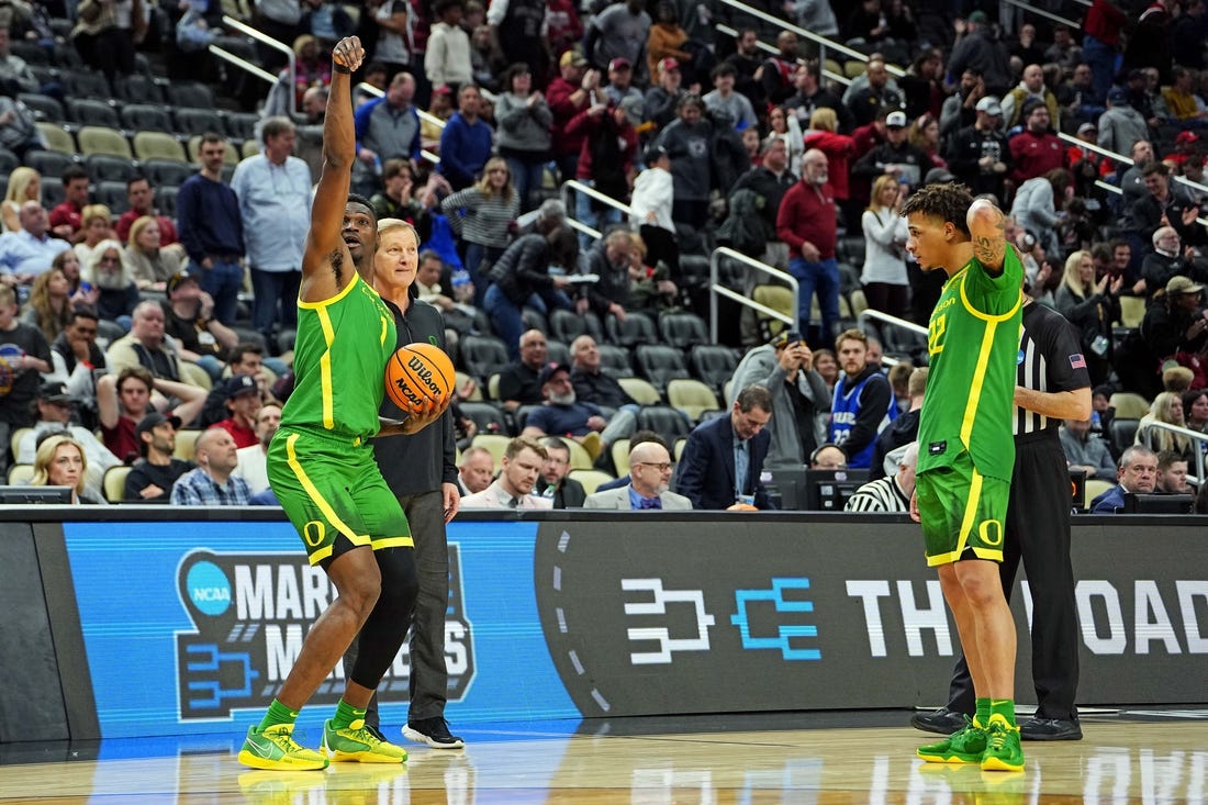 Mar 21, 2024; Pittsburgh, PA, USA; Oregon Ducks center N'Faly Dante (1) and guard Jadrian Tracey (22) celebrate with head coach Dana Altman after beating the South Carolina Gamecocks in the first round of the 2024 NCAA Tournament at PPG Paints Arena. Mandatory Credit: Gregory Fisher-USA TODAY Sports
