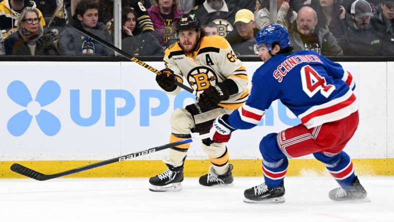 Mar 21, 2024; Boston, Massachusetts, USA; Boston Bruins right wing David Pastrnak (88) shoots the puck in front of New York Rangers defenseman Braden Schneider (4) during the first period at the TD Garden. Mandatory Credit: Brian Fluharty-USA TODAY Sports