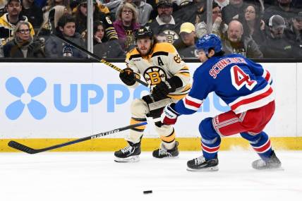 Mar 21, 2024; Boston, Massachusetts, USA; Boston Bruins right wing David Pastrnak (88) shoots the puck in front of New York Rangers defenseman Braden Schneider (4) during the first period at the TD Garden. Mandatory Credit: Brian Fluharty-USA TODAY Sports