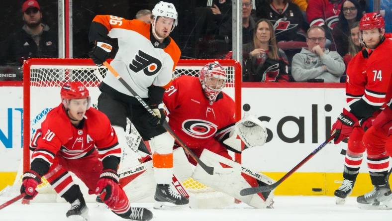 Mar 21, 2024; Raleigh, North Carolina, USA; Carolina Hurricanes goaltender Frederik Andersen (31) and Philadelphia Flyers left wing Joel Farabee (86) watch the shot during the first period at PNC Arena. Mandatory Credit: James Guillory-USA TODAY Sports