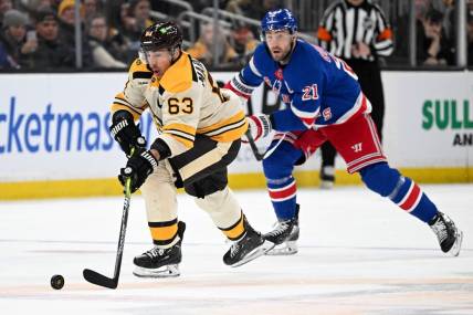 Mar 21, 2024; Boston, Massachusetts, USA; Boston Bruins left wing Brad Marchand (63) skates with the puck against New York Rangers center Barclay Goodrow (21) during the second period at the TD Garden. Mandatory Credit: Brian Fluharty-USA TODAY Sports