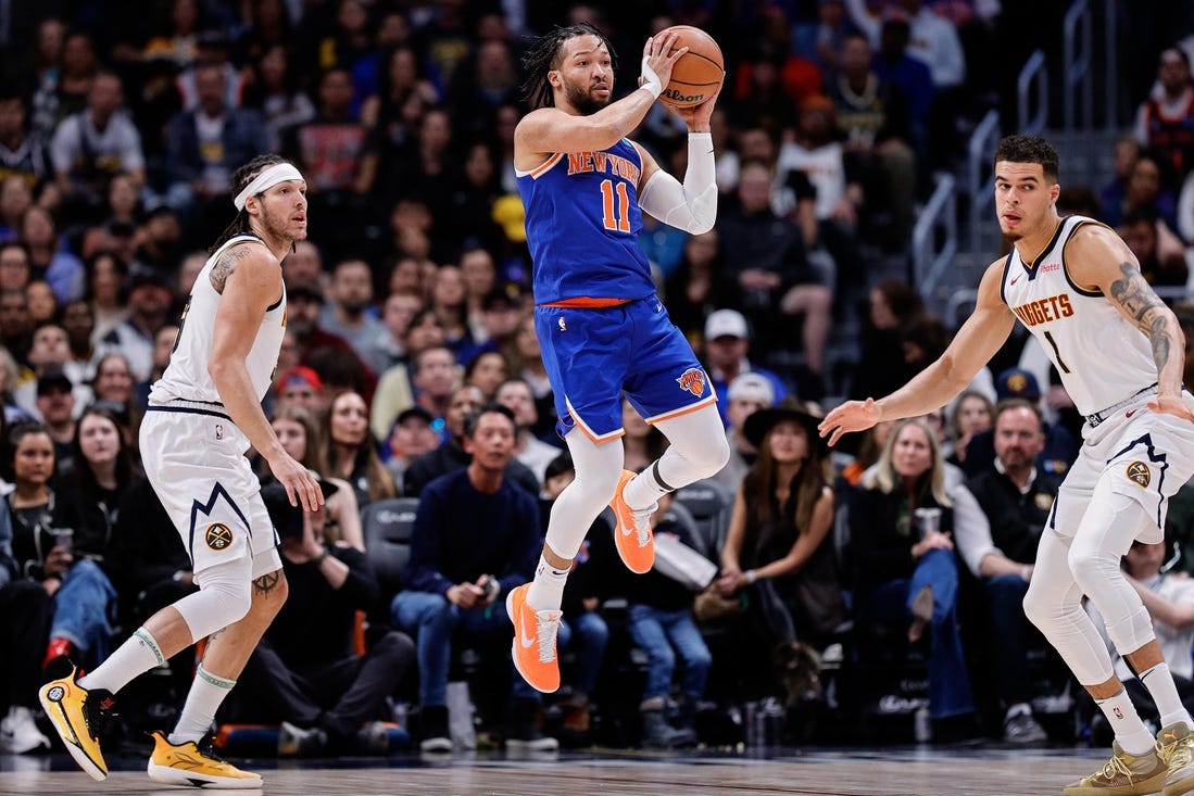 Mar 21, 2024; Denver, Colorado, USA; New York Knicks guard Jalen Brunson (11) controls the ball as Denver Nuggets forward Aaron Gordon (50) and ]forward Michael Porter Jr. (1) defend in the first quarter at Ball Arena. Mandatory Credit: Isaiah J. Downing-USA TODAY Sports