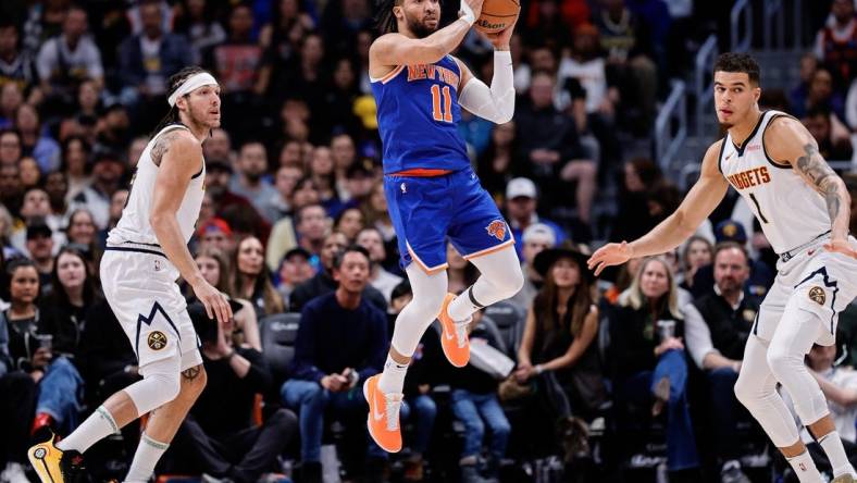 Mar 21, 2024; Denver, Colorado, USA; New York Knicks guard Jalen Brunson (11) controls the ball as Denver Nuggets forward Aaron Gordon (50) and ]forward Michael Porter Jr. (1) defend in the first quarter at Ball Arena. Mandatory Credit: Isaiah J. Downing-USA TODAY Sports